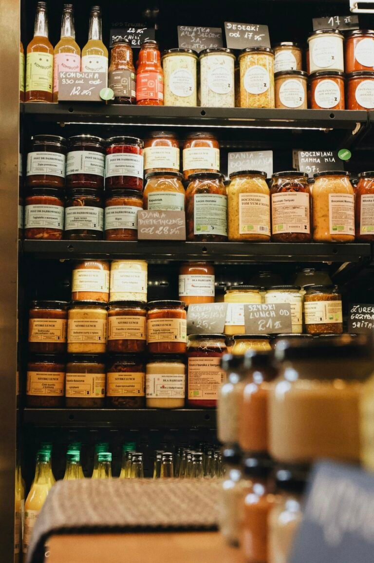 Assorted jars and bottles neatly arranged on market shelves in a Polish store.