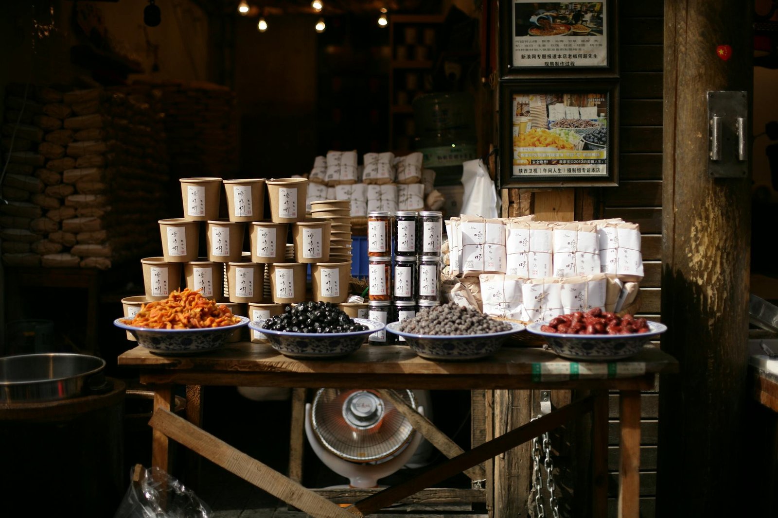 Charming street market with neatly stacked jars, spices, and diverse products on display.